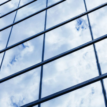 Glass Skyscraper Building With Cloudy Blue Sky